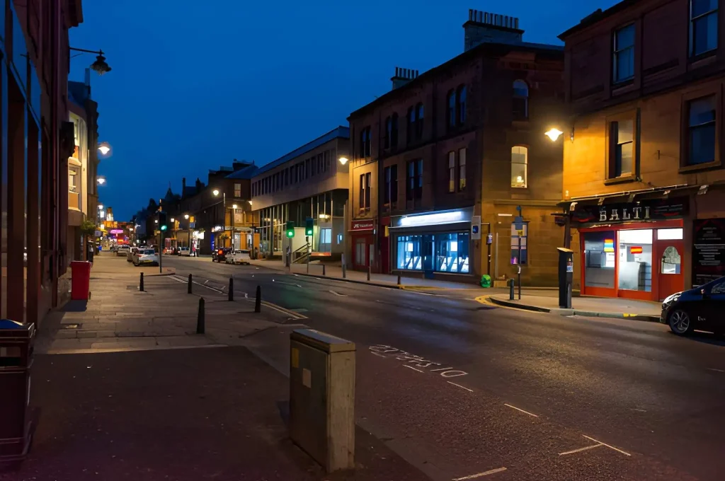 Night street view in Kilmarnock town centre, a key service location with vibrant local businesses and traffic.